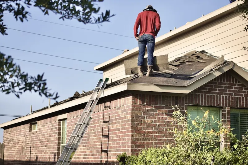 Professional roofer working on a residential roof in Westpark Village